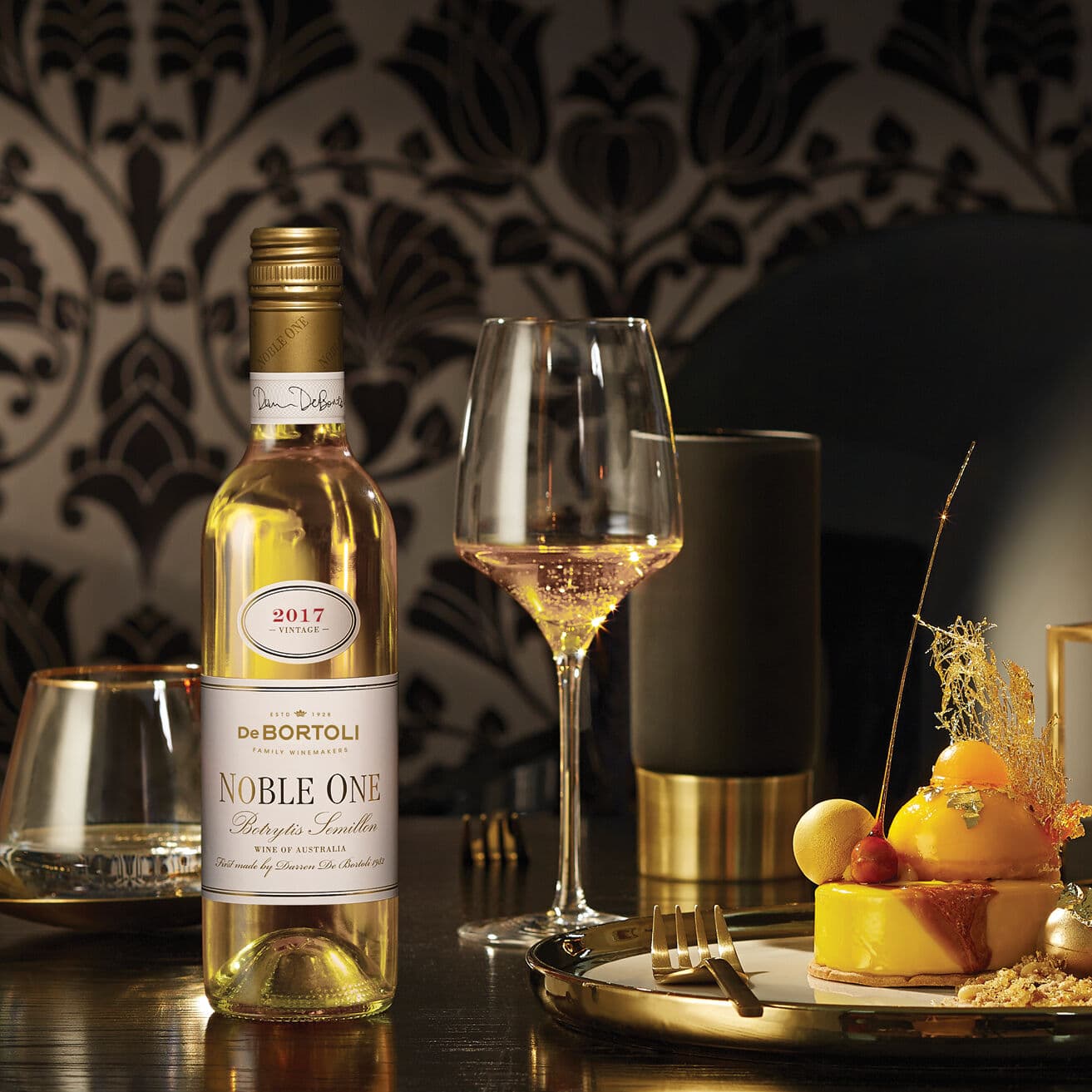 Bottle of Noble One placed on a table setting with desserts