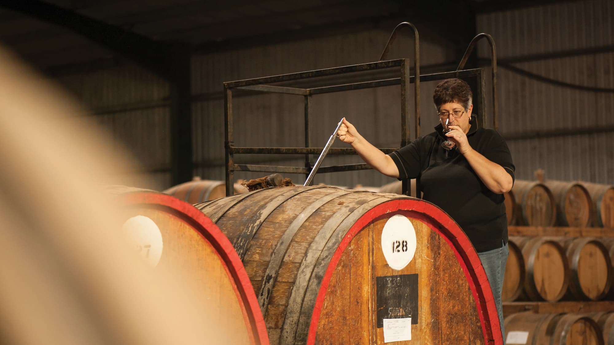 Julie Mortlock, De Bortoli Winemaker at our Bilbul winery, Riverina, checking fortified wine in barrel room