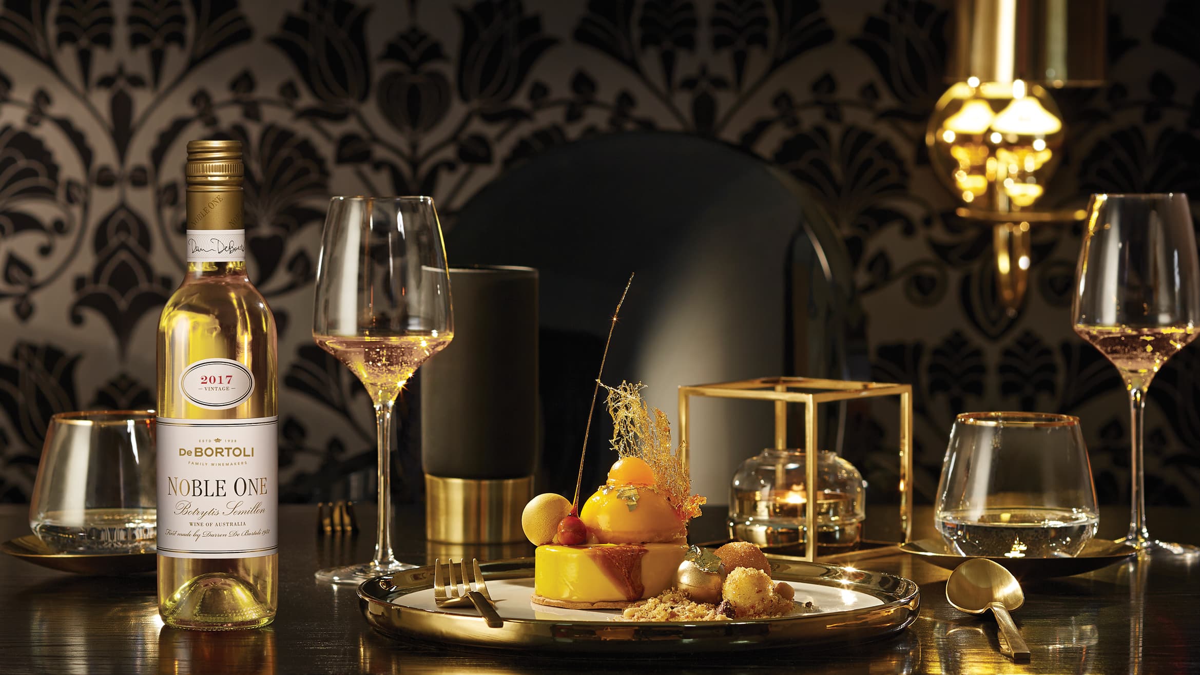Bottle of Noble One placed on a table setting with desserts
