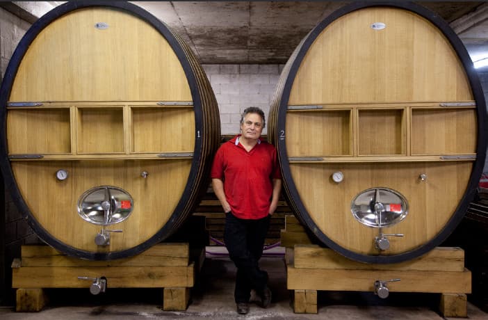 Steve Webber standing between two large barrels